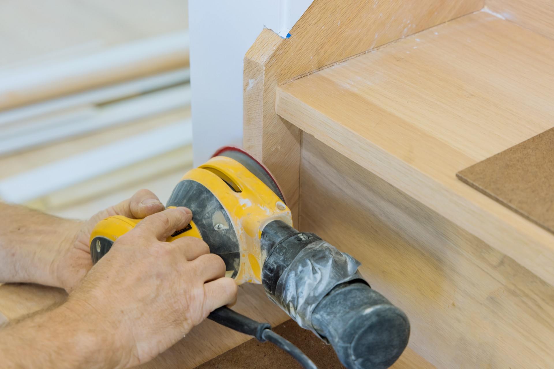 Carpeted grinding using a polishing machine refinishing the stairwell of railing in a new home