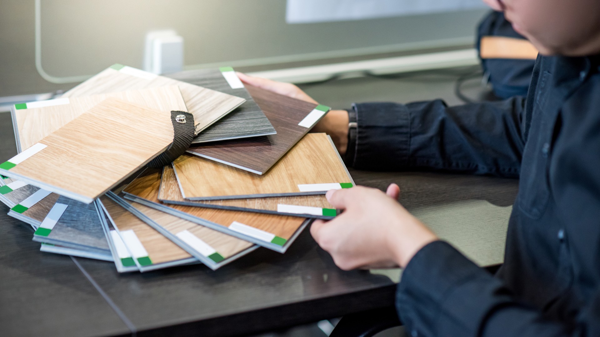 Asian architect man choosing wooden color swatch